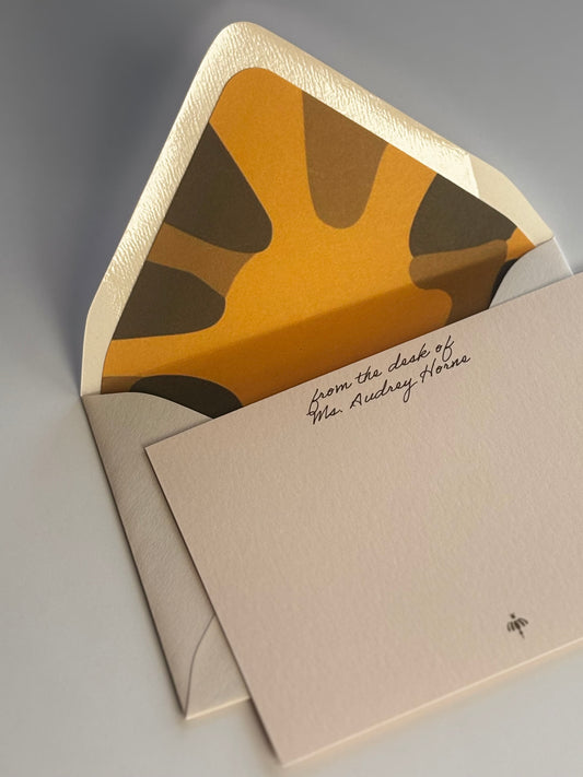 Close-up of Poppy stationery showing personalized script and the envelope’s gold and green floral liner.