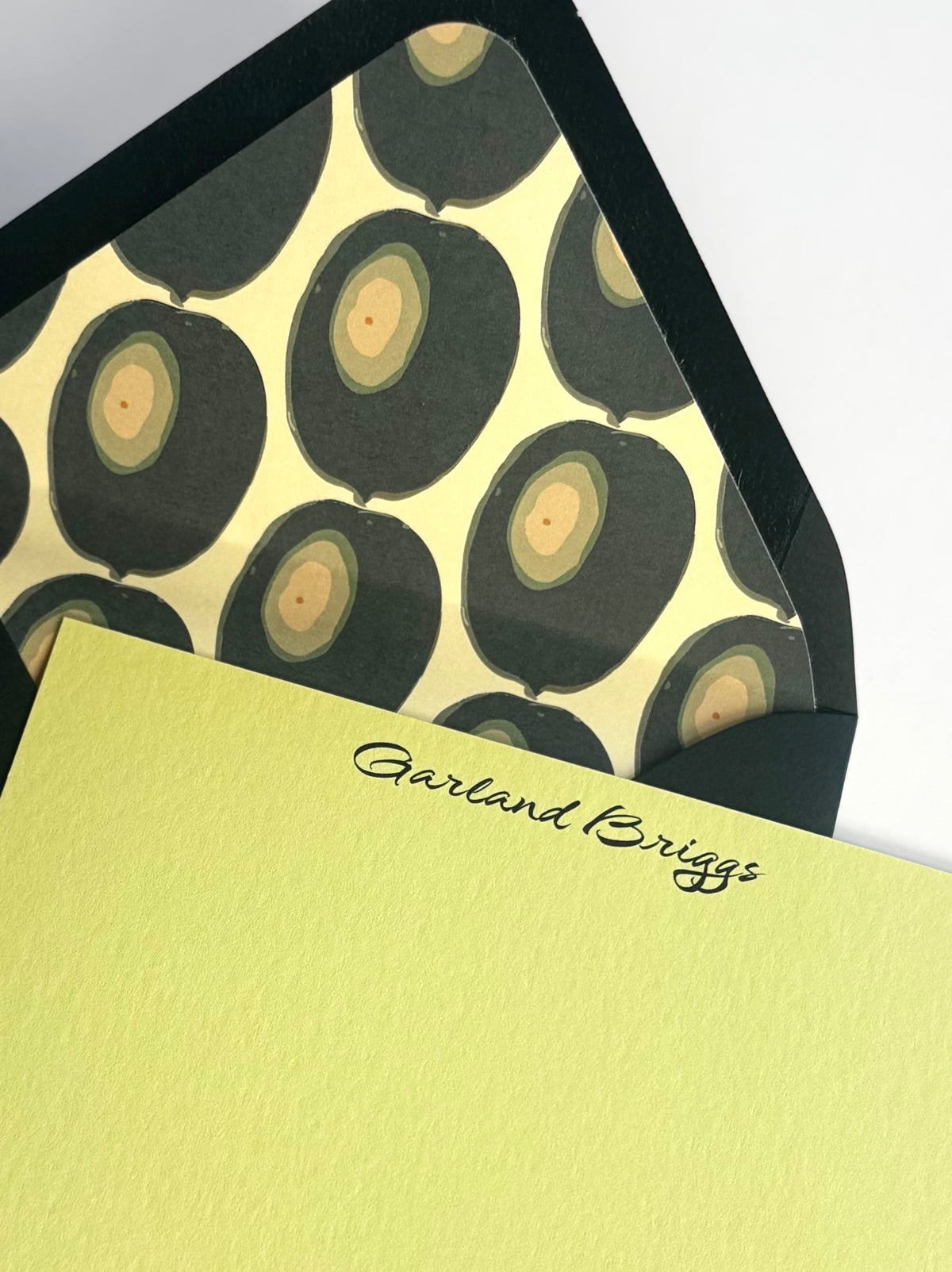 Close-up of Martini Olive stationery showing personalized script and the envelope’s green olive-patterned liner.