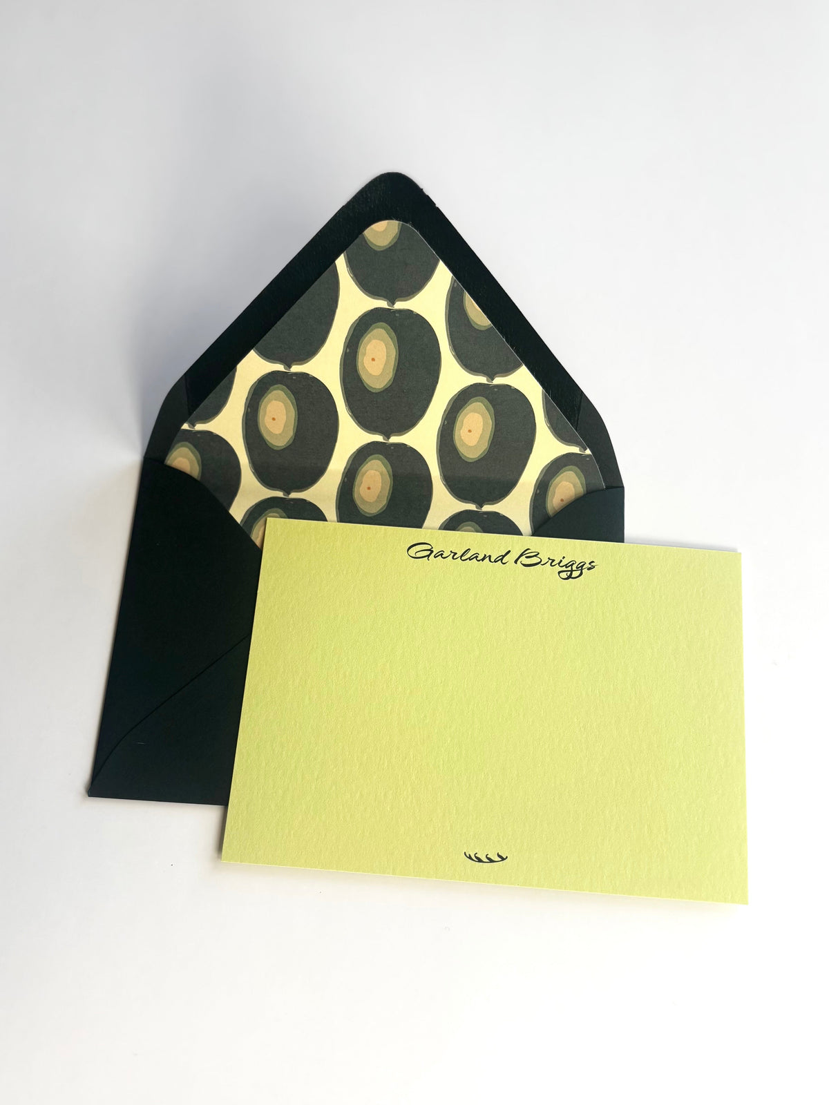 Martini Olive personalized yellow-green notecard with an open dark envelope lined in a repeating olive pattern.