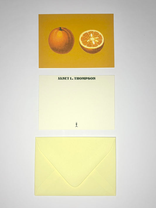 Golden Orange stationery set showing an orange-illustrated back, personalized cream front, and pale yellow envelope.