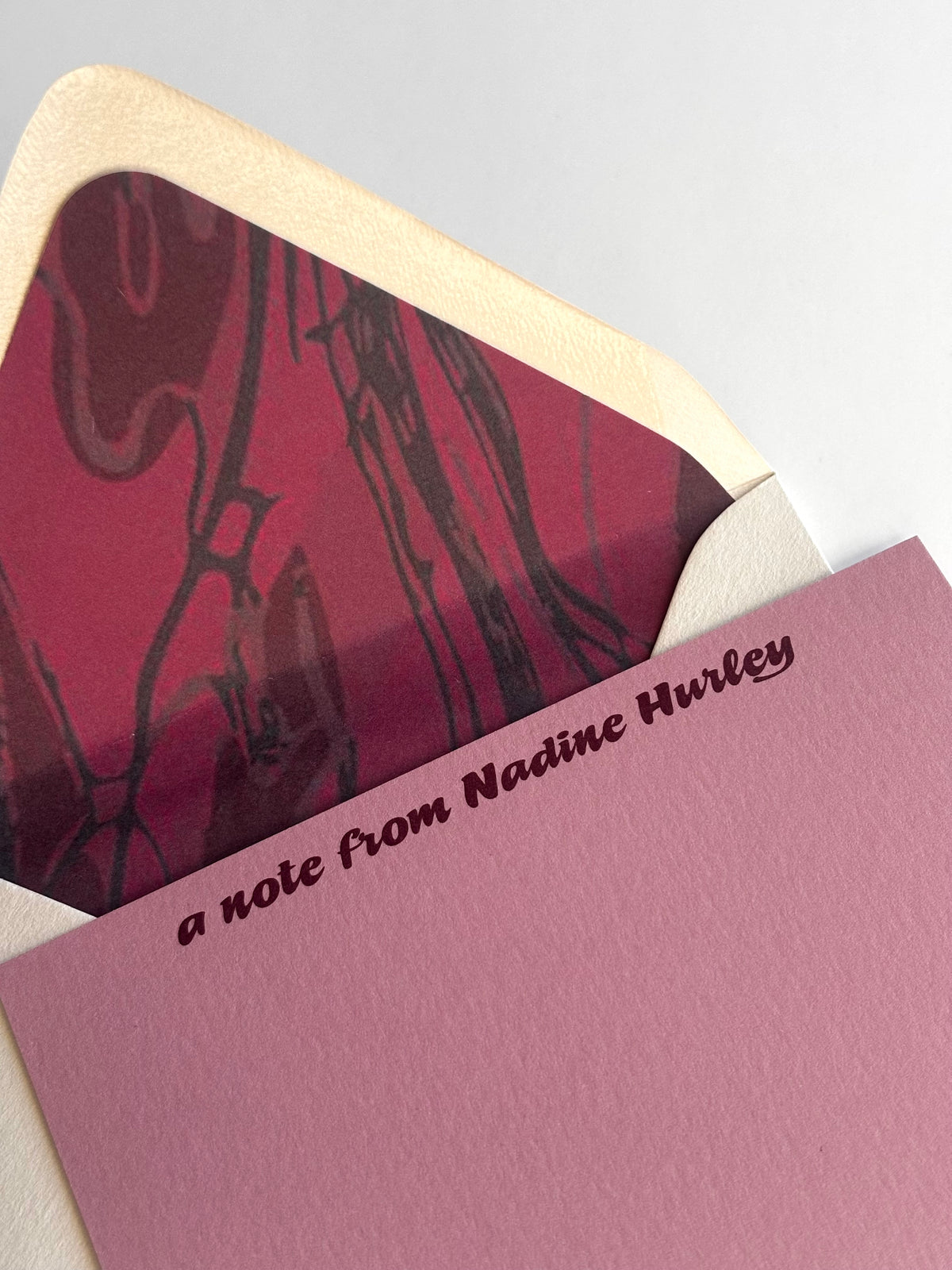 Close-up of Meandering River stationery showing personalized lettering and the envelope's deep red river liner.