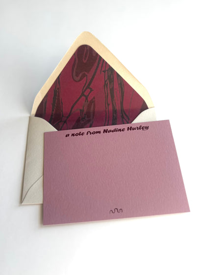 Meandering River personalized dusty pink notecard with an open cream envelope lined in a deep wine river pattern.
