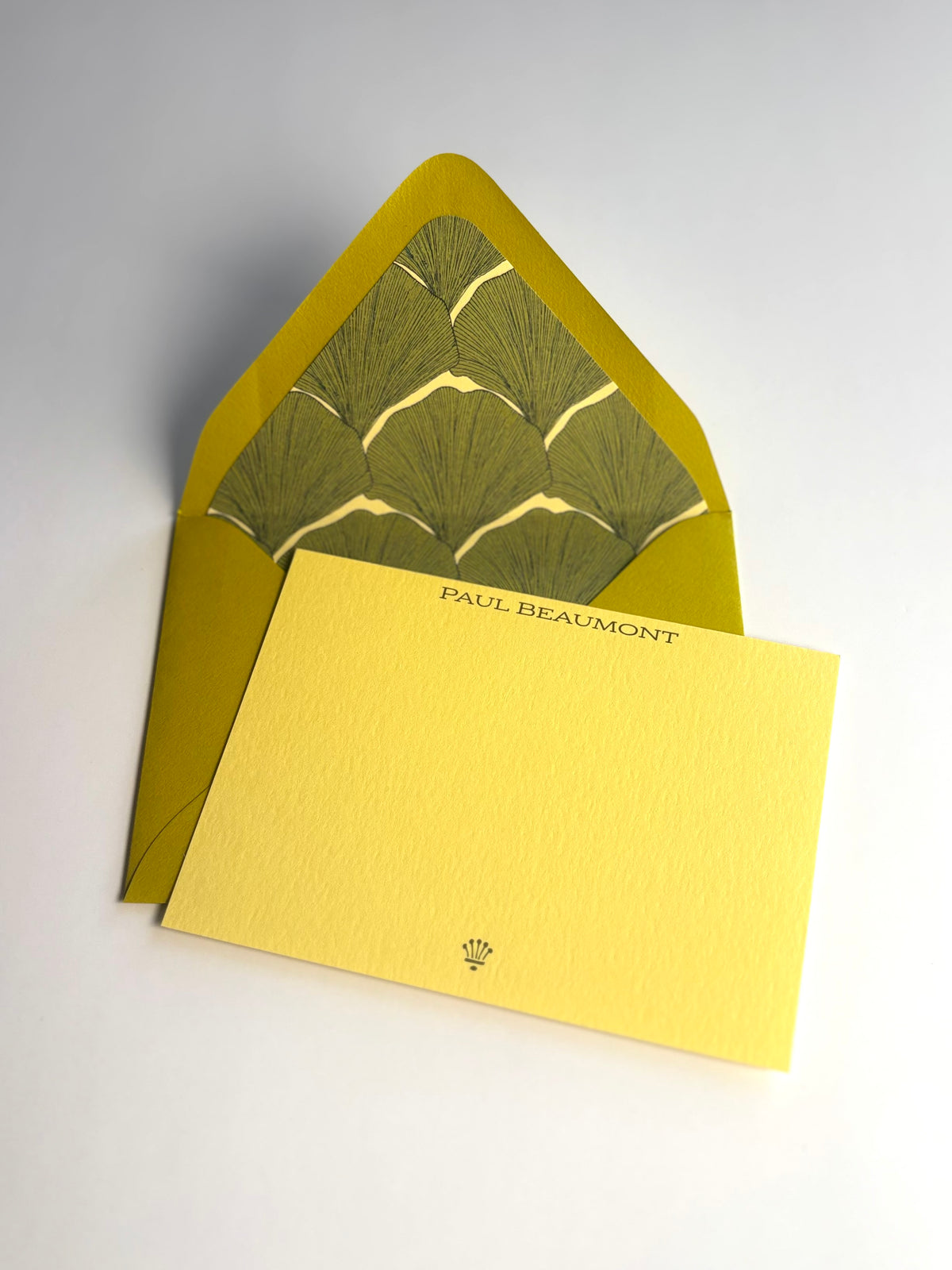 Living Fossil personalized soft gold notecard with an open chartreuse envelope lined in a green ginkgo leaf pattern.