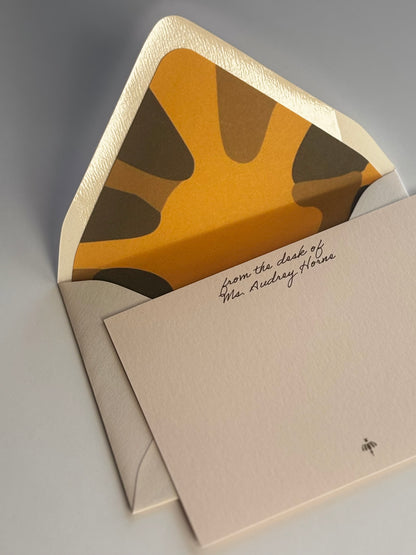Close-up of Poppy stationery showing personalized script and the envelope’s gold and green floral liner.