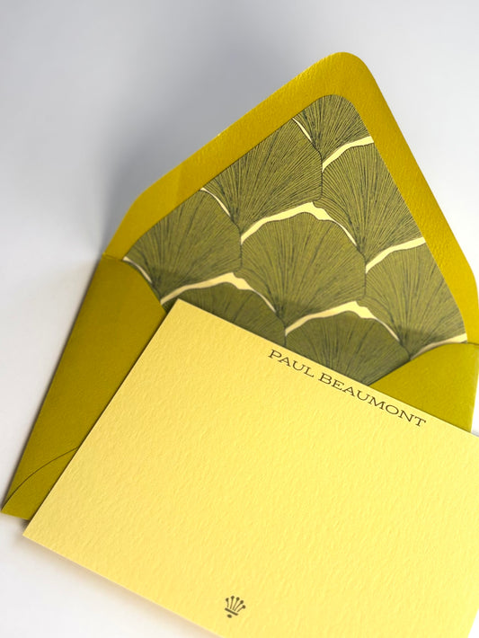 Close-up of a personalized soft gold Living Fossil notecard and the envelope’s overlapping green ginkgo leaf liner.
