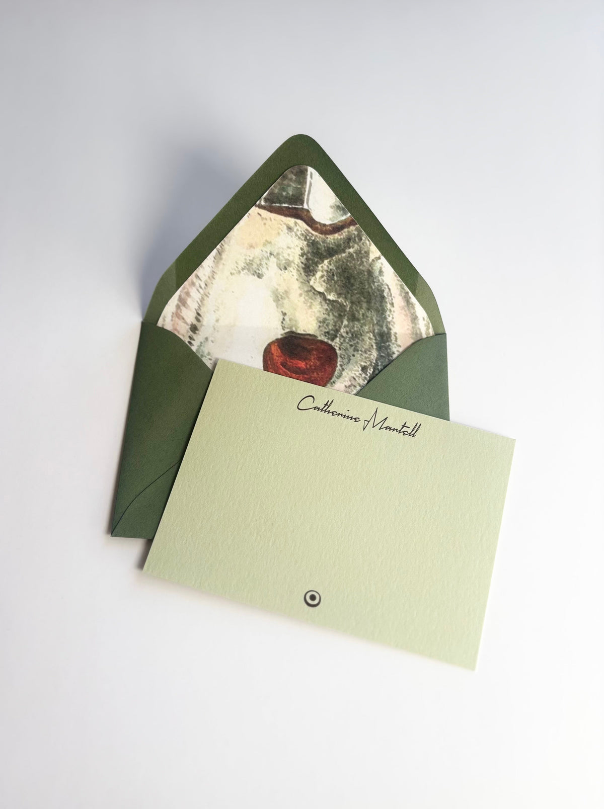 The Half Shell personalized pale green notecard with an open dark green envelope lined in an oyster shell illustration.